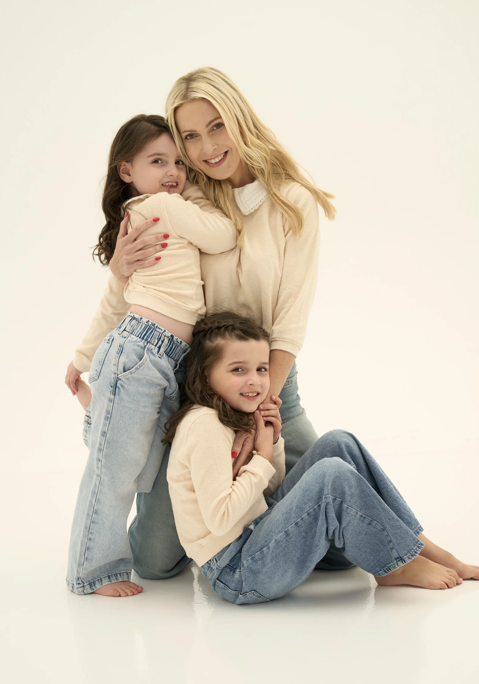 The family on the floor together, the girls leaning into their mother